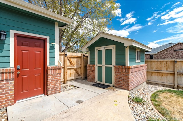 view of shed with a fenced backyard and a gate