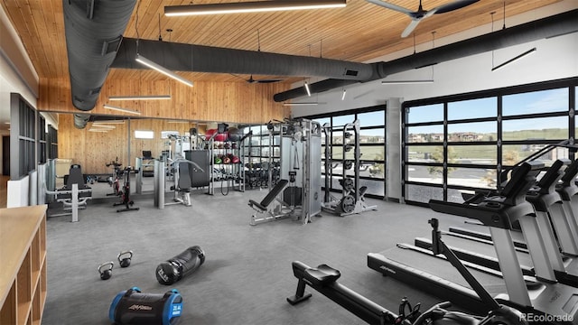 workout area featuring a high ceiling, ceiling fan, wood walls, and wood ceiling