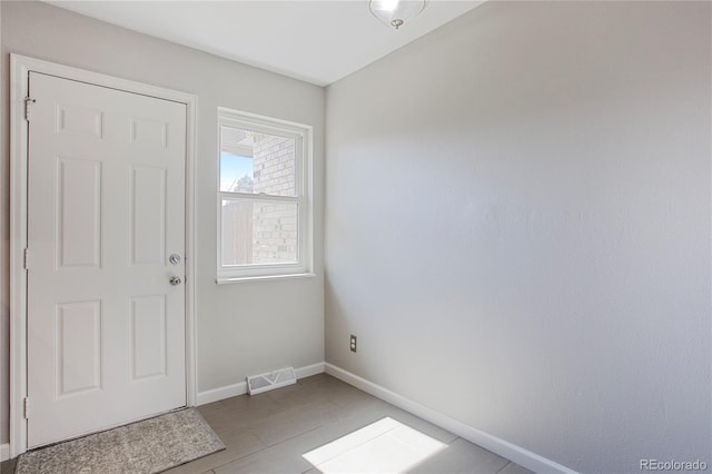 foyer entrance with visible vents and baseboards