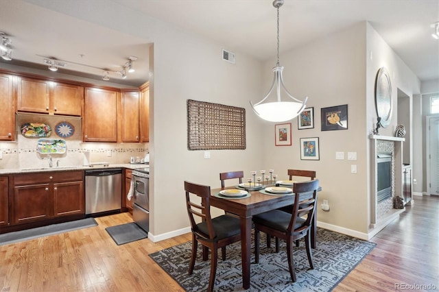 7865 Vallagio Ln Unit 207, Englewood, CO 80112 - dining space with light wood-style floors and a glass covered fireplace