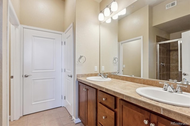 bathroom with tile patterned flooring, vanity, and a shower with door