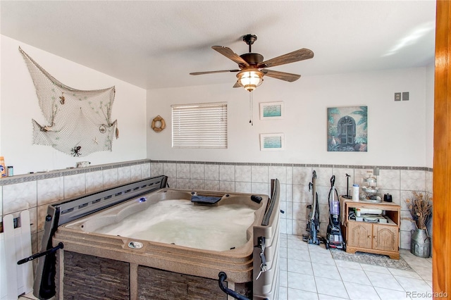 interior space featuring ceiling fan, light tile patterned floors, and tile walls