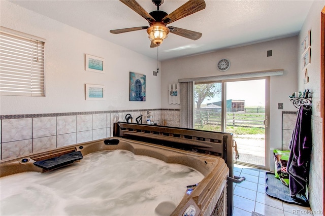 bedroom with access to exterior, light tile patterned floors, a textured ceiling, and ceiling fan