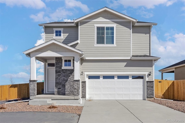 craftsman-style home featuring a garage, stone siding, fence, and concrete driveway
