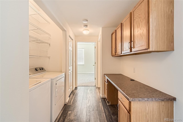 clothes washing area with dark wood-style flooring and washer and clothes dryer