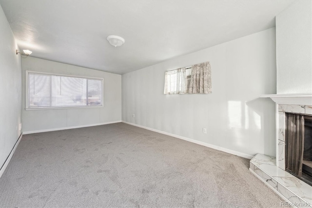 unfurnished living room featuring a premium fireplace and carpet flooring