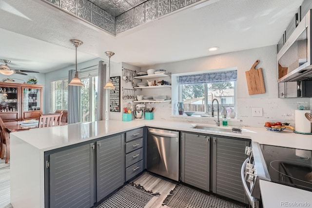 6311 Xavier St, Arvada, CO 80003 - kitchen featuring gray cabinetry, stainless steel appliances, a peninsula, and healthy amount of natural light