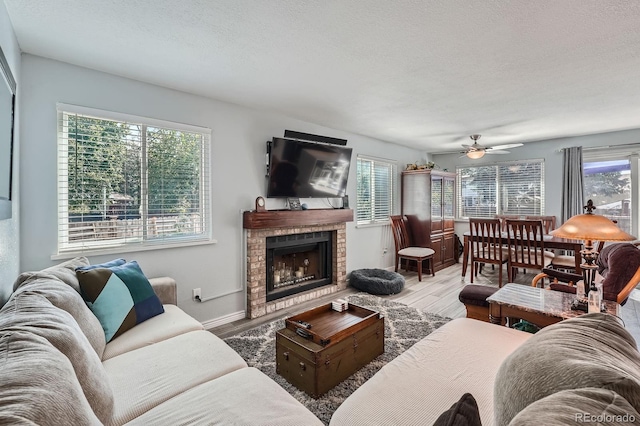 6311 Xavier St, Arvada, CO 80003 - living room with wood finished floors, a brick fireplace, plenty of natural light, a ceiling fan, and a textured ceiling