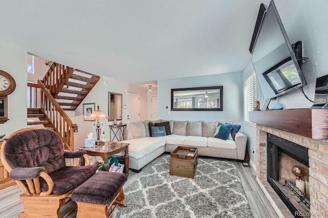 6311 Xavier St, Arvada, CO 80003 - living room with wood finished floors, stairway, and a brick fireplace
