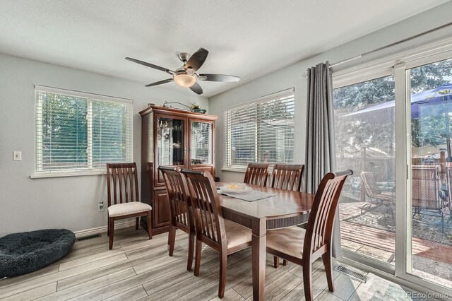 6311 Xavier St, Arvada, CO 80003 - dining room with plenty of natural light, ceiling fan, light wood-type flooring, and baseboards