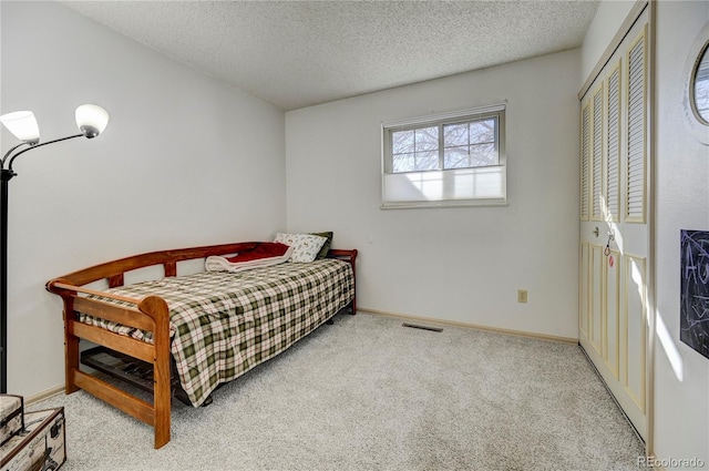 carpeted bedroom featuring a textured ceiling