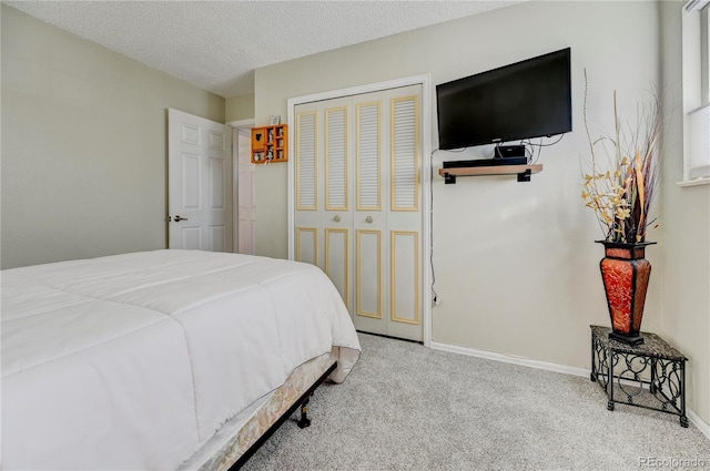 carpeted bedroom with a closet and a textured ceiling