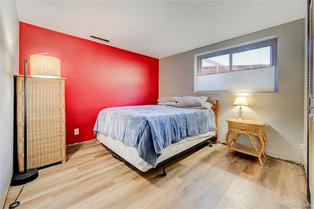 bedroom with wood-type flooring and a textured ceiling