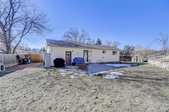 back of house with a shed, a yard, and a patio