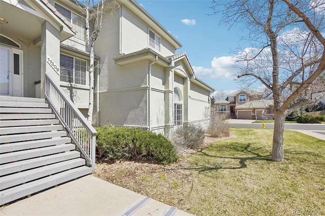 17309 Witten Ct, Parker, CO 80134 - view of side of property with a yard, stairway, a residential view, and stucco siding