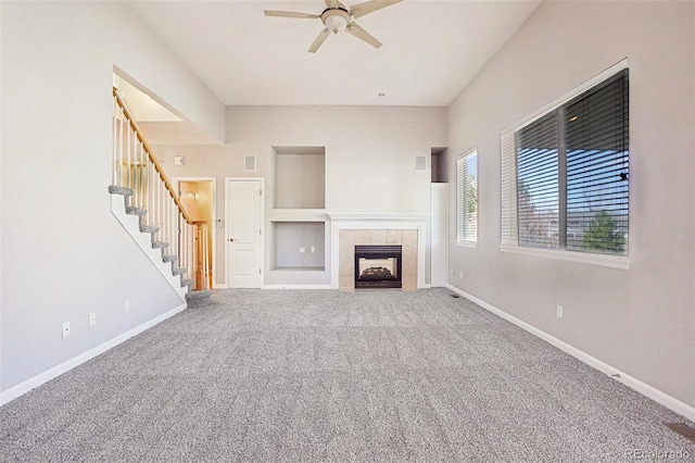 17309 Witten Ct, Parker, CO 80134 - unfurnished living room with baseboards, a tiled fireplace, stairway, ceiling fan, and carpet