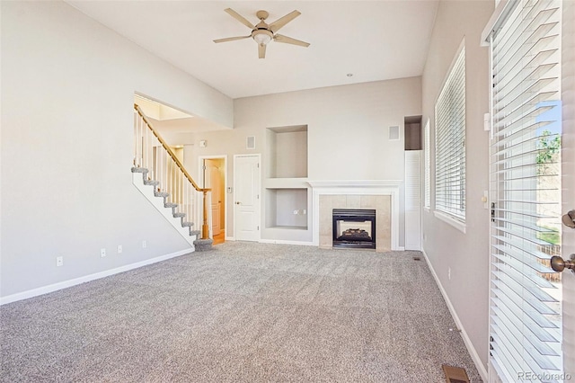 17309 Witten Ct, Parker, CO 80134 - unfurnished living room with visible vents, baseboards, a tiled fireplace, ceiling fan, and stairs