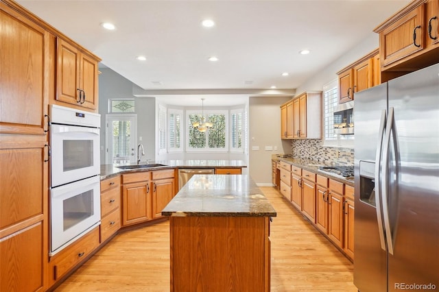 17309 Witten Ct, Parker, CO 80134 - kitchen with a peninsula, light wood-style floors, a sink, and appliances with stainless steel finishes