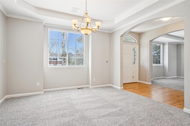 17309 Witten Ct, Parker, CO 80134 - entryway with baseboards, an inviting chandelier, a raised ceiling, arched walkways, and carpet
