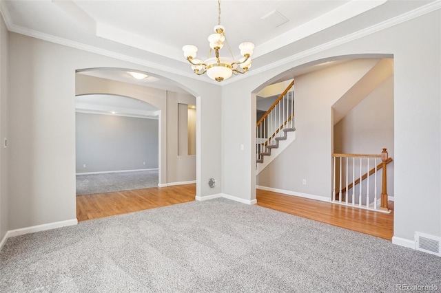 17309 Witten Ct, Parker, CO 80134 - spare room with an inviting chandelier, visible vents, a tray ceiling, arched walkways, and carpet