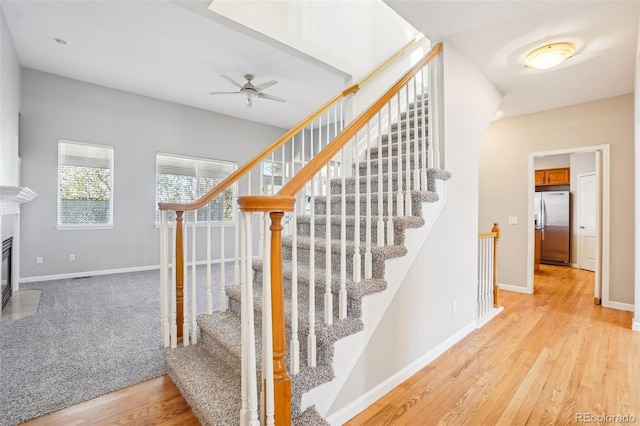 17309 Witten Ct, Parker, CO 80134 - stairway with a fireplace with flush hearth, wood finished floors, ceiling fan, and baseboards