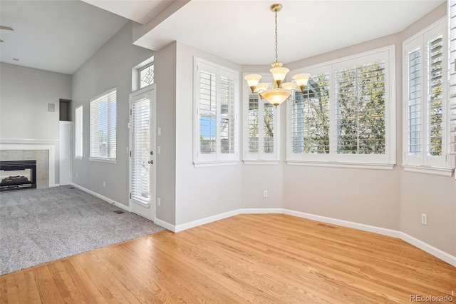 17309 Witten Ct, Parker, CO 80134 - interior space featuring a tiled fireplace, a notable chandelier, baseboards, and wood finished floors