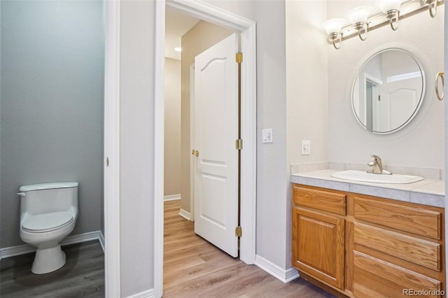 17309 Witten Ct, Parker, CO 80134 - bathroom featuring toilet, vanity, wood finished floors, and baseboards