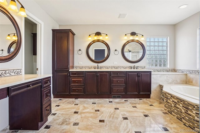 17309 Witten Ct, Parker, CO 80134 - bathroom with double vanity, visible vents, a relaxing tiled tub, and a sink