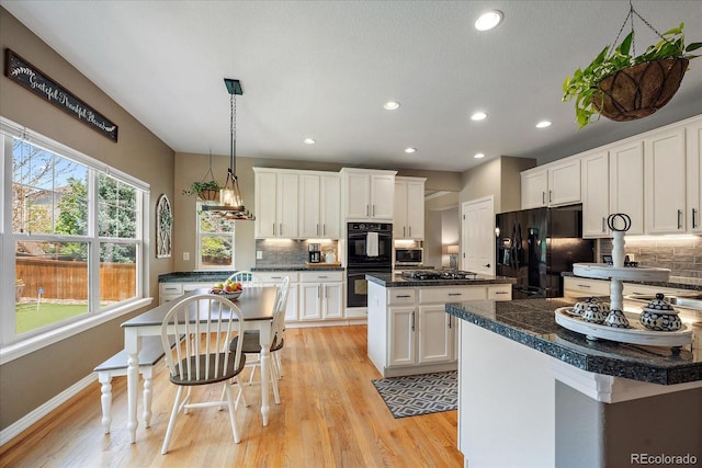 2861 Madison Ln, Broomfield, CO 80023 - kitchen with black appliances, a center island, healthy amount of natural light, recessed lighting, and backsplash