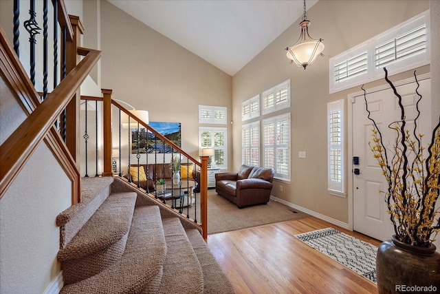 2861 Madison Ln, Broomfield, CO 80023 - entryway featuring high vaulted ceiling, stairway, wood finished floors, and baseboards