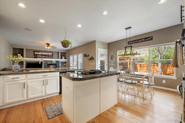 2861 Madison Ln, Broomfield, CO 80023 - kitchen featuring ceiling fan, a sink, a center island, white cabinets, and light wood-style flooring