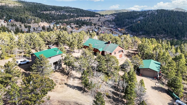 birds eye view of property with a wooded view and a mountain view