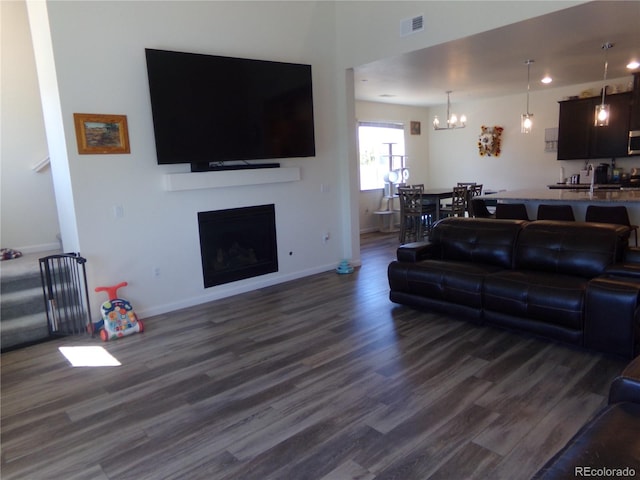 living room with a chandelier and dark hardwood / wood-style floors