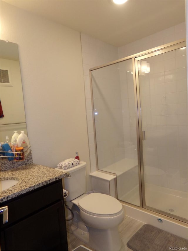 bathroom with toilet, vanity, and walk in shower