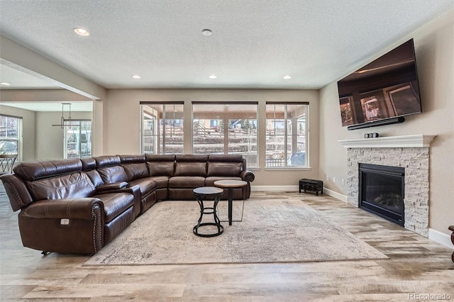 living area featuring recessed lighting, a fireplace, a textured ceiling, and wood finished floors