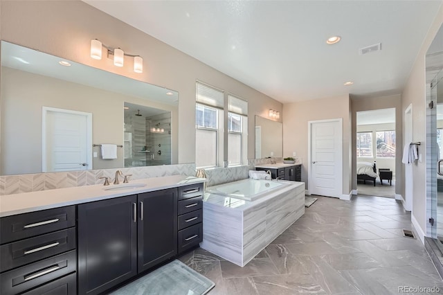 full bath with visible vents, connected bathroom, a garden tub, vanity, and a shower stall