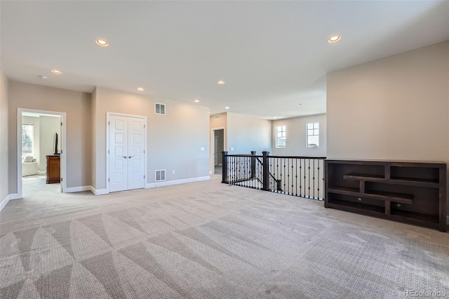 spare room with light carpet, baseboards, visible vents, and recessed lighting