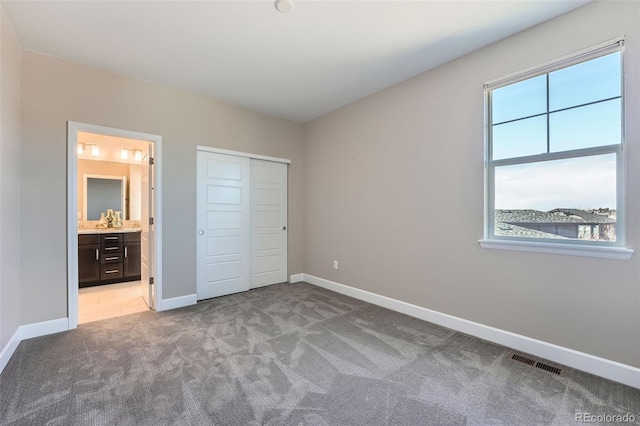 unfurnished bedroom with baseboards, multiple windows, visible vents, and light colored carpet