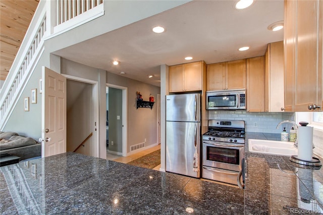 362 Kite Ct, Jefferson, CO 80456 - kitchen with appliances with stainless steel finishes, light brown cabinetry, tasteful backsplash, recessed lighting, and a peninsula