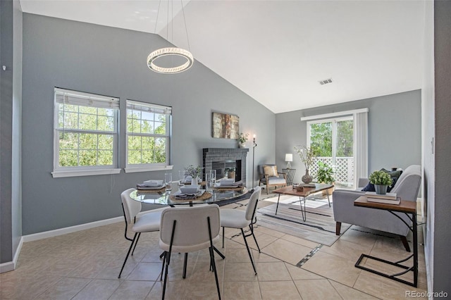 360 S Estes St Unit C, Lakewood, CO 80228 - dining room with a glass covered fireplace, light tile patterned flooring, high vaulted ceiling, and baseboards