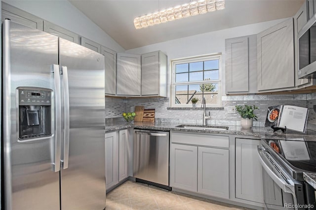 360 S Estes St Unit C, Lakewood, CO 80228 - kitchen featuring appliances with stainless steel finishes, a sink, vaulted ceiling, gray cabinets, and stone countertops