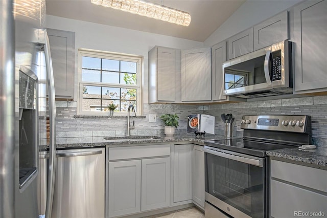 360 S Estes St Unit C, Lakewood, CO 80228 - kitchen with appliances with stainless steel finishes, a sink, tasteful backsplash, dark stone countertops, and lofted ceiling