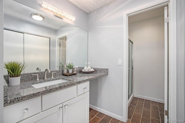 360 S Estes St Unit C, Lakewood, CO 80228 - bathroom with wood tiled floors, baseboards, vanity, and an enclosed shower
