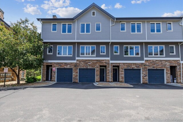 2945 W Riverwalk Cir Unit B, Littleton, CO 80123 - multi unit property with driveway, stone siding, and a garage