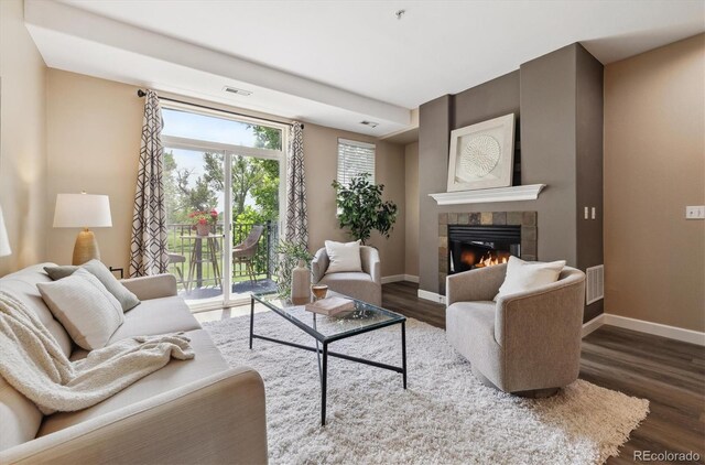 2945 W Riverwalk Cir Unit B, Littleton, CO 80123 - living room featuring wood finished floors, a fireplace, and baseboards