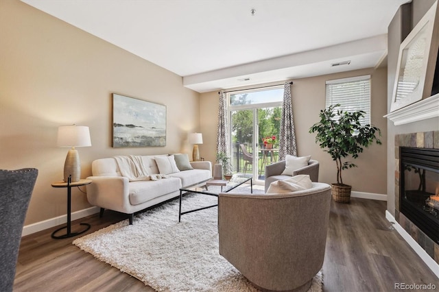 2945 W Riverwalk Cir Unit B, Littleton, CO 80123 - living area with a tiled fireplace, baseboards, and dark wood-style flooring
