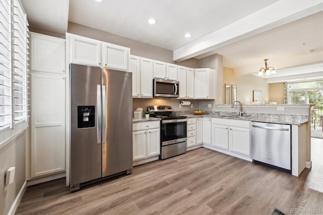2945 W Riverwalk Cir Unit B, Littleton, CO 80123 - kitchen with stainless steel appliances, a sink, recessed lighting, beam ceiling, and light wood finished floors