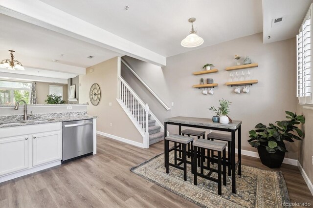 2945 W Riverwalk Cir Unit B, Littleton, CO 80123 - dining area with stairs, light wood-type flooring, baseboards, and a chandelier