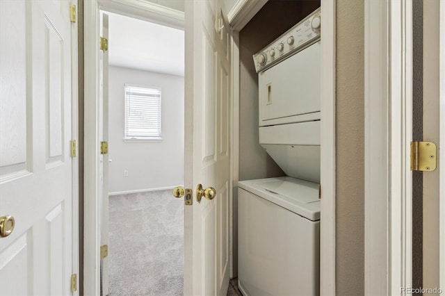 2945 W Riverwalk Cir Unit B, Littleton, CO 80123 - washroom with stacked washer / dryer, carpet floors, and baseboards