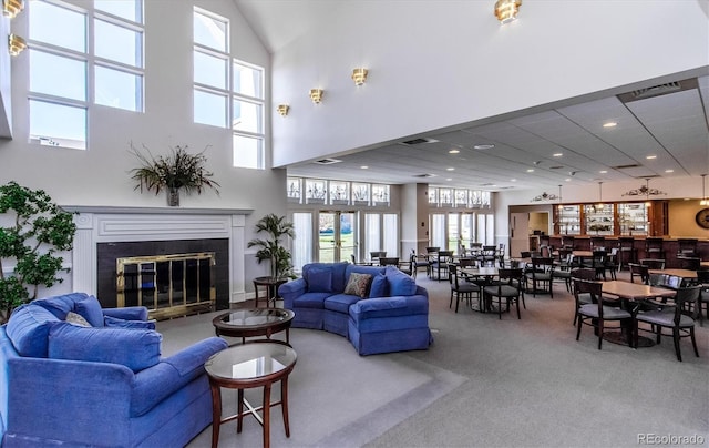 2945 W Riverwalk Cir Unit B, Littleton, CO 80123 - living area featuring carpet floors, a glass covered fireplace, a towering ceiling, and recessed lighting